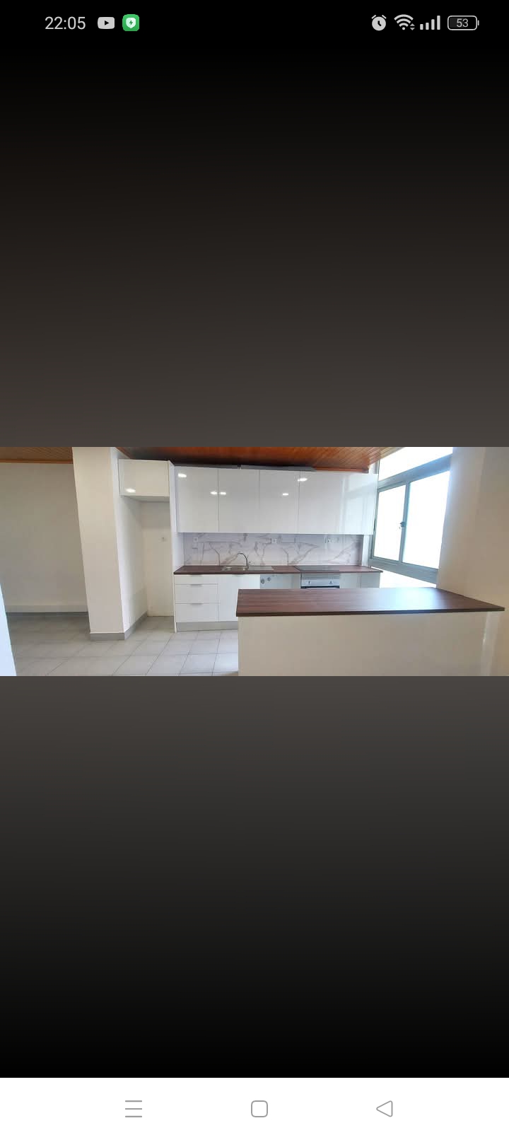 Cozinha branca espaçosa remodelada com teto em madeira Lisboa